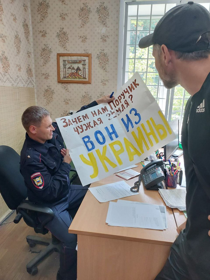 Полицейские с антивоенным плакатом Дмитрия Рыкова, август 2023 г. / Фото из личного архива