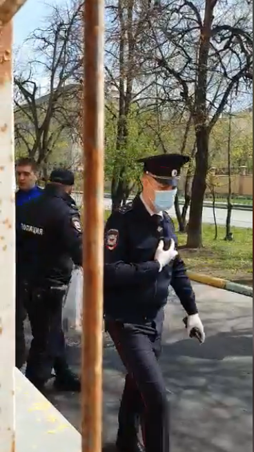 Полицейский пытается помешать передать продукты заблокированным в офисе / Скриншоты из видео Фатимы Хугаевой в фейсбуке Полицейский пытается помешать передать продукты заблокированным в офисе / Скриншоты из видео Фатимы Хугаевой в фейсбуке