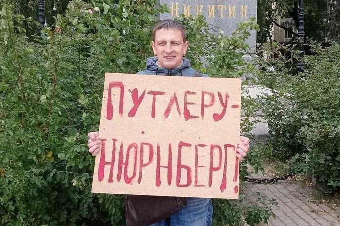 <em>Григорий Северин в одиночном пикете. За этот же плакат в январе 2021 года его <a href="https://mekodxpr-bsccljbcrq-ez.a.run.app/express-news/2021/01/20/voronezhca-arestovali-iz-za-odinochnogo-piketa-v-podderzhku-navalnogo"><u>арестовали</u></a> на пять суток (ч. 8 ст. 20.2 КоАП РФ) / Фото: Свободные Люди Воронежа</em>