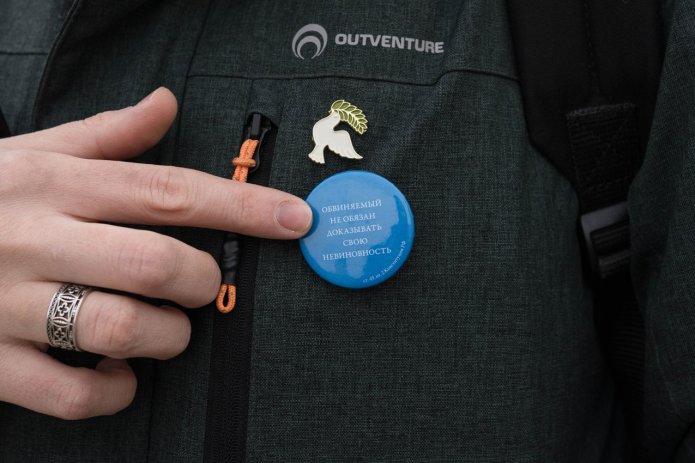 A badge with a quote from Article 49 of the Constitution: «The accused shall not be obligated to prove their innocence» on Tatyana Levicheva’s jacket. Photo by Ksenia Maximova for OVD-Info