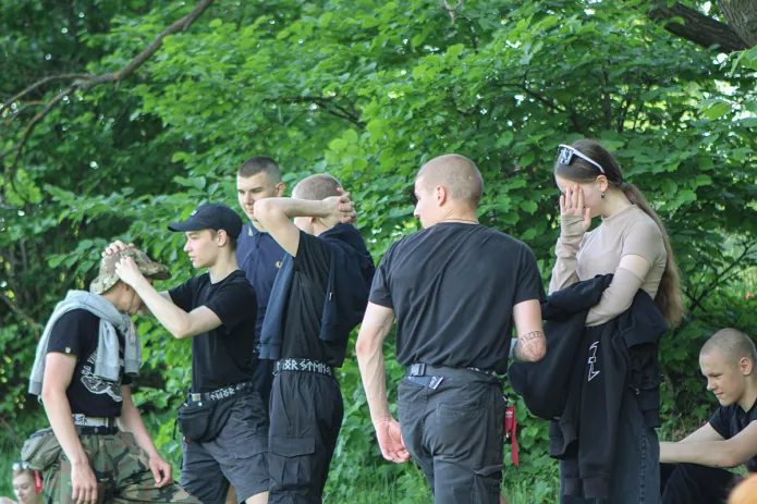 <em>Молодые люди в черной одежде с неонацистской символикой неподалеку от места проведения «Хиппятника» в парке Царицыно, 1 июня 2024 год / Фото: Адель Максимова, группа «Хиппятник!!!» во «ВКонтакте»</em>